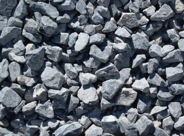 A close-up view of a pile of 3/4 Bluestone (per yard) gravel, showcasing stones of varying sizes and shapes that fill the entire frame. The bluestone pieces have rough textures and angular edges, creating a rugged appearance—perfect for landscaping projects that might also need topsoil delivery in Brooklyn County.